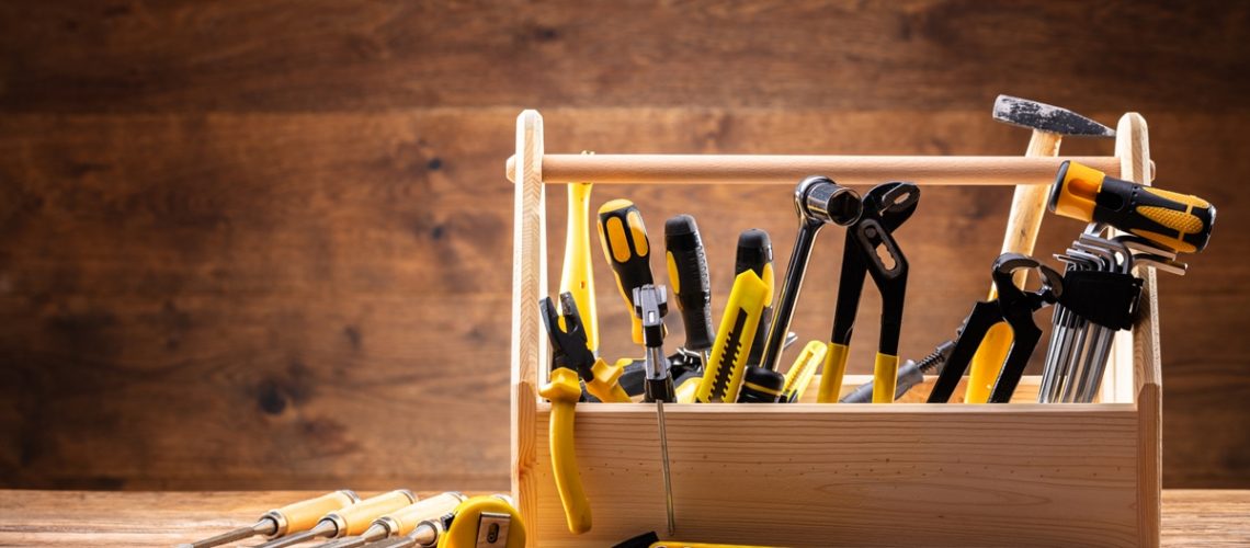 Toolbox With Various Worktools On Wooden Surface
